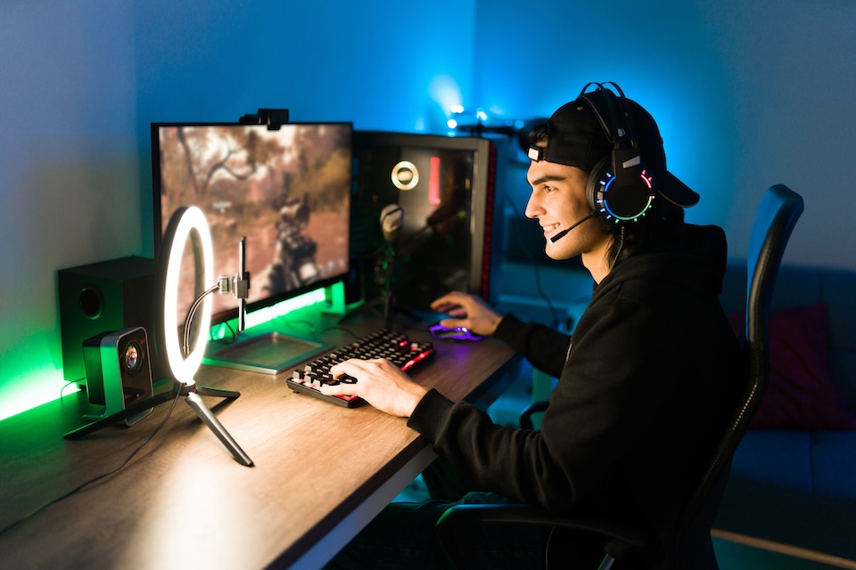 Man sitting at desk with multiple monitors and smart home devices