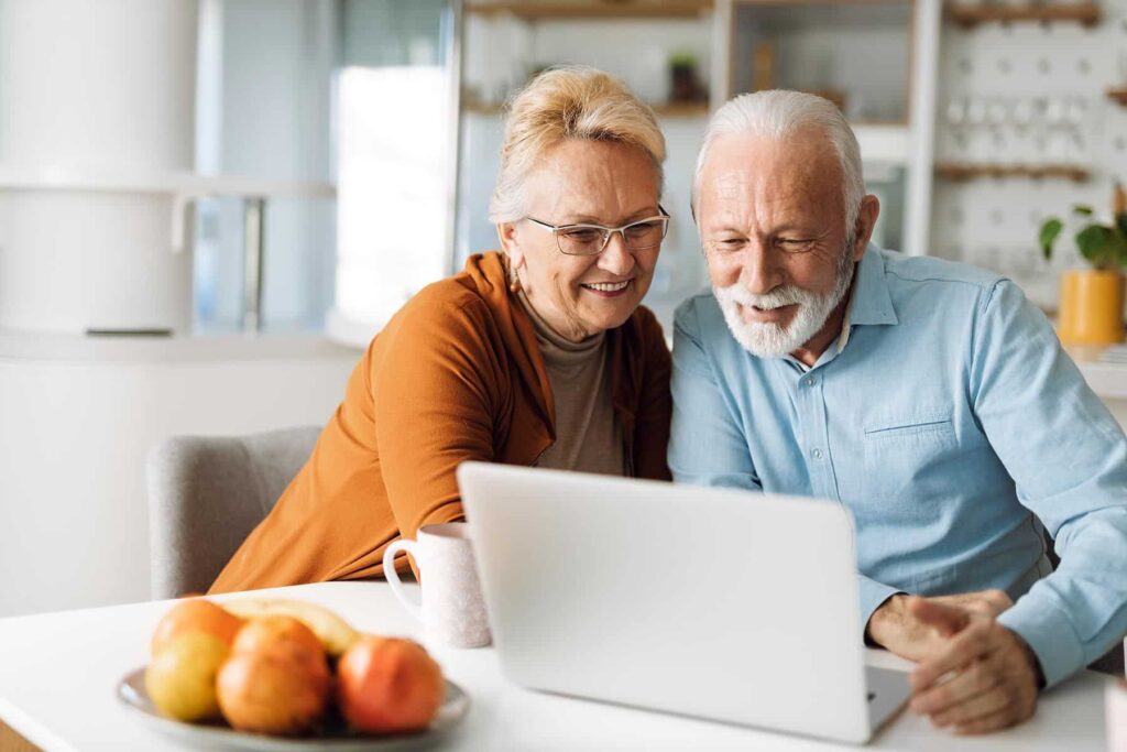 elderly couple looking at laptop