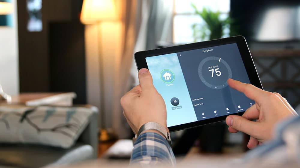 hands holding tablet screen looking at smart home thermostat from Mercury