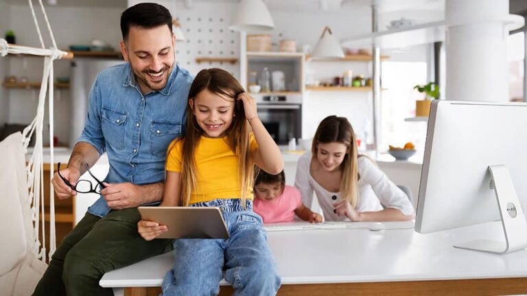 man with daughter looking at tablet