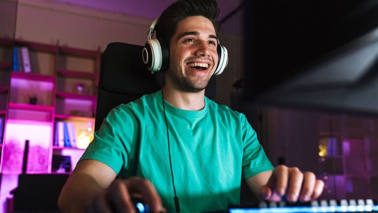 happy man with headphones sitting at gaming computer with fast gaming speeds from Mercury