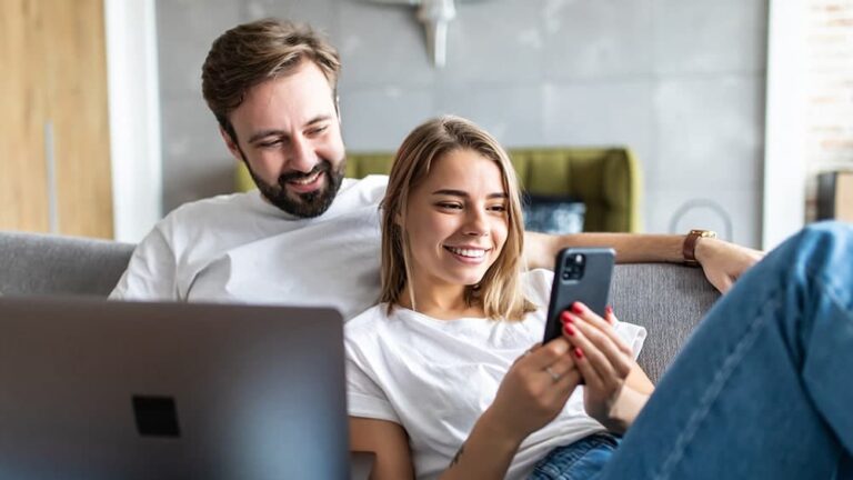 man and woman on couch smiling
