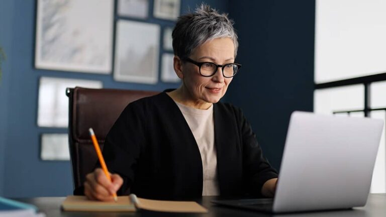 woman with glasses sitting at desk