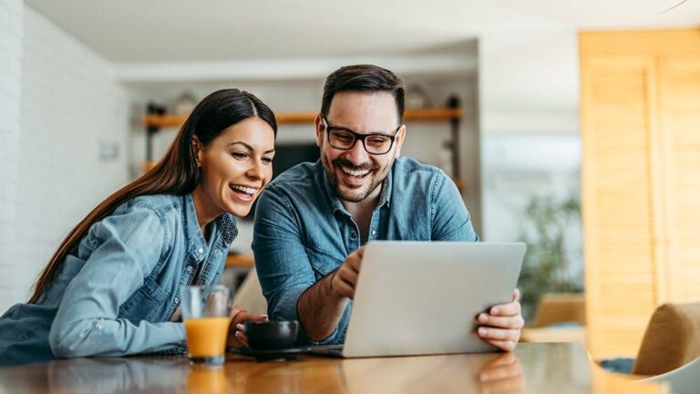 excited man and woman looking at tablet with fast home internet from Mercury