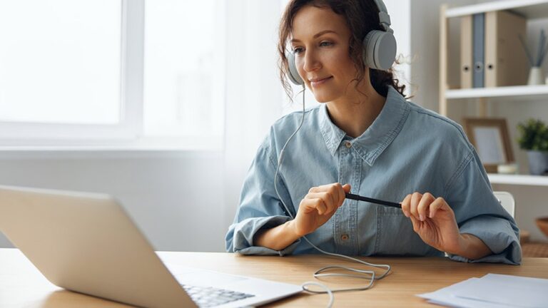 woman sitting with headphones at a desk