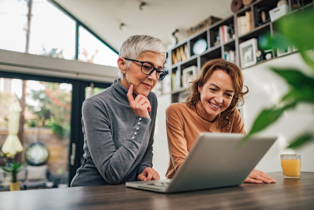 two women sitting at laptop computer enjoying fast home internet from Mercury