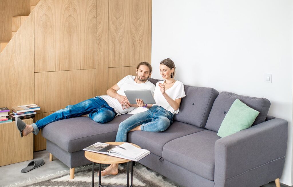Couple on the couch looking at their laptop