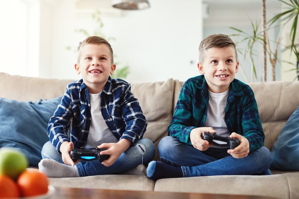 Two kids play video games on the TV