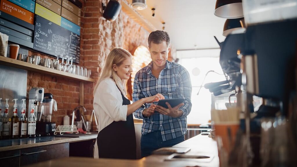 Two Coffee Shop workers look at a tablet