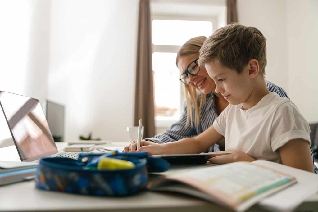 A woman and her son doing school work on a laptop
