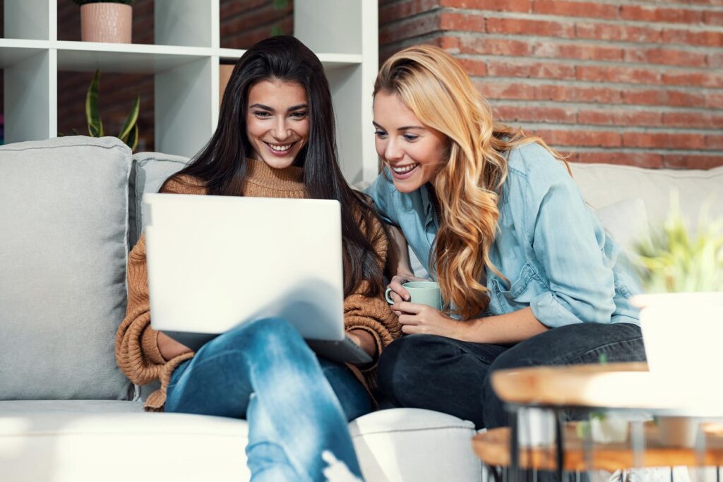 Two friends looking at a laptop together