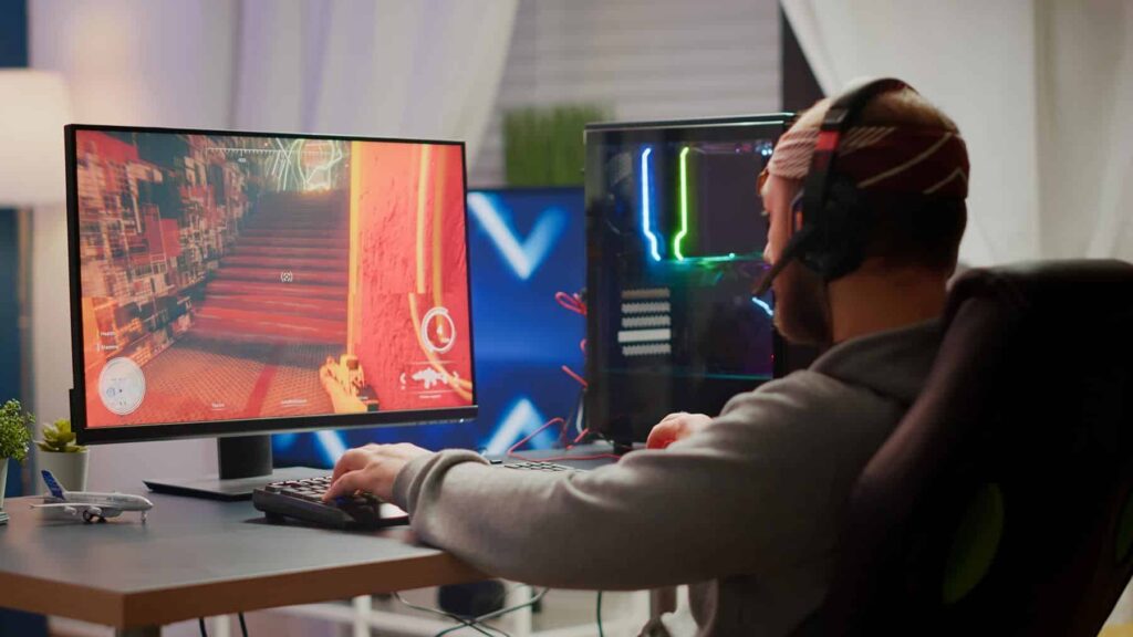 man sitting at computer playing video game