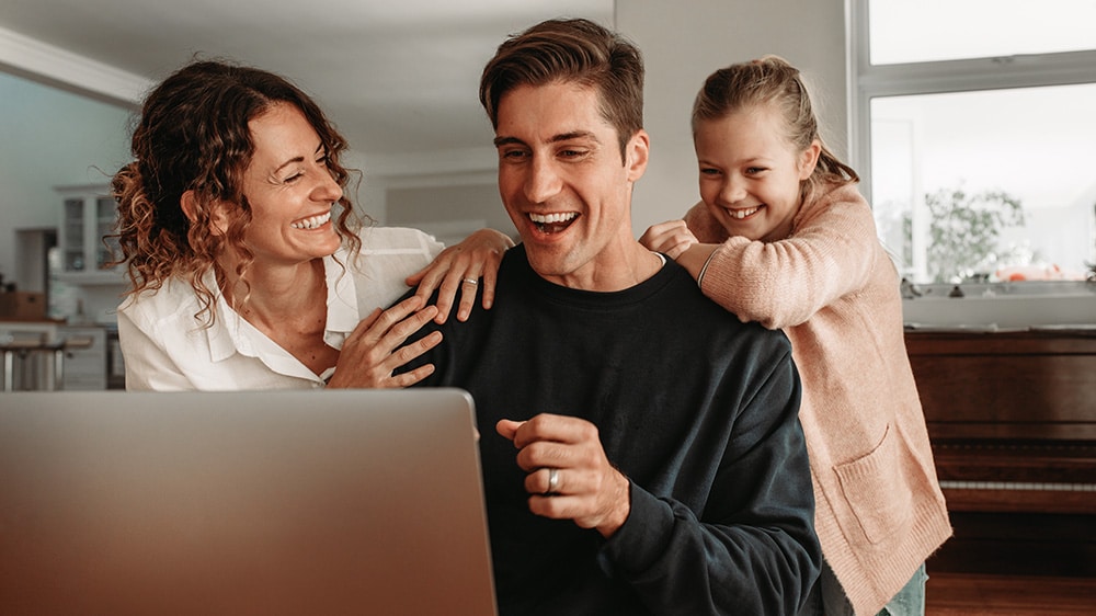 excited family looking at laptop