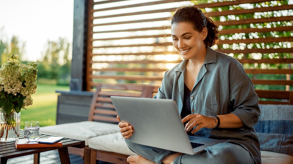 woman sitting outside with laptop enjoying fast home internet from Mercury