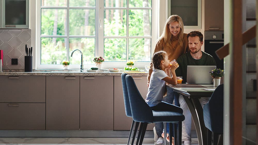 family using laptop in kitchen