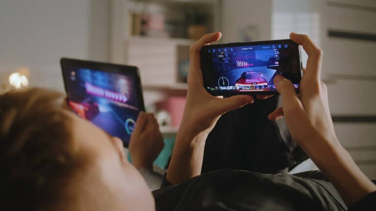 Kids playing games on a smartphone and tablet.