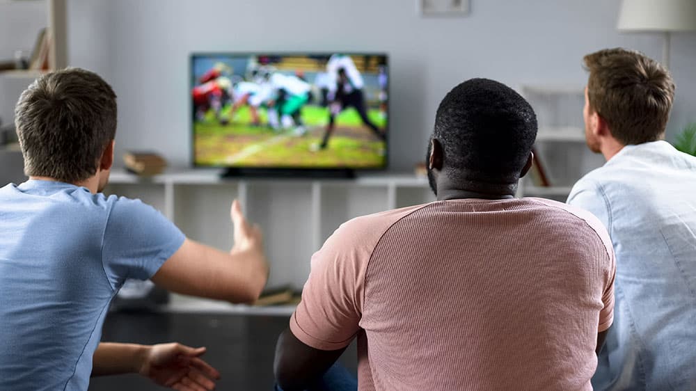 Group of friends watching sports on TV