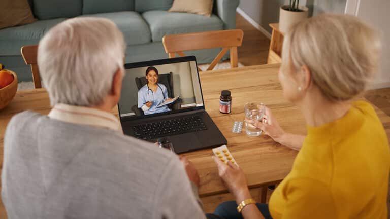 Senior couple using telehealth on a laptop